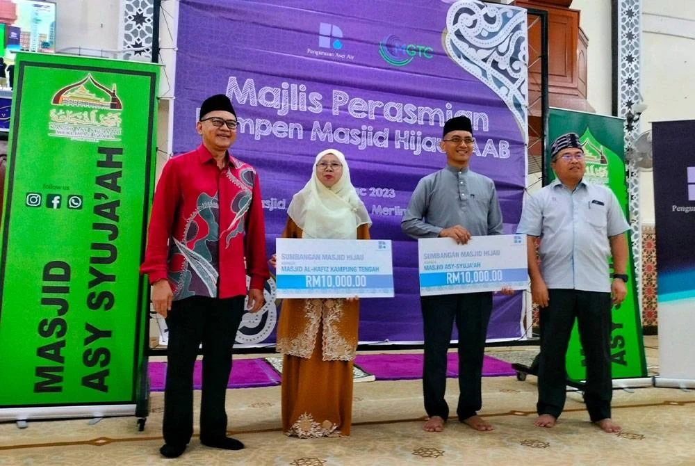 Shamsul Bahar (kiri) dan Abdul Hadi (kanan) bersama dua wakil masjid yang menerima peruntukan RM10,000 ketika Kempen Masjid Hijau Pengurusan Aset Air Berhad di Masjid Asy Syuja'ah Merlimau pada Sabtu.