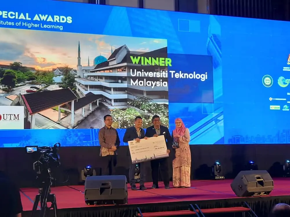   Prof Ts Dr Mohd Hamdan Ahmad and Ms Noor Azlinda Maskor receiving the award from YB Tuan Nik Nazmi Nik Ahmad, Minister of Natural Resources, Environment and Climate Change