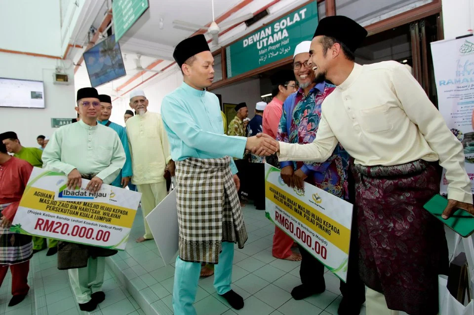 Nik Nazmi berbual-bual dengan sebahagian penerima Dana Wakaf Majis Hijau pada majlis di Masjid Al-Hasanah, Bandar Baru Bangi. - Foto NSTP/AIZUDDIN SAAD