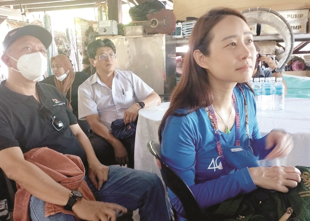 Jacqueline Chang listening to a briefing by Adrian Lasimbang in Tonibung-‘Friends of Village Development project. Behind her is Prof Dr Ho Chin Siong.