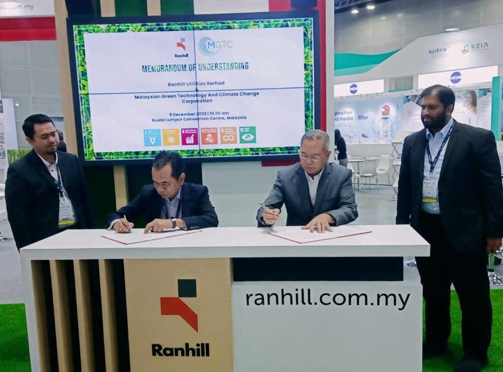 Amran Awaluddin (left) and Shamsul Bahar pen their signatures at the Ranhill’s booth during the ASIAWATER Expo & Forum 2022 in the Kuala Lumpur Convention Centre.