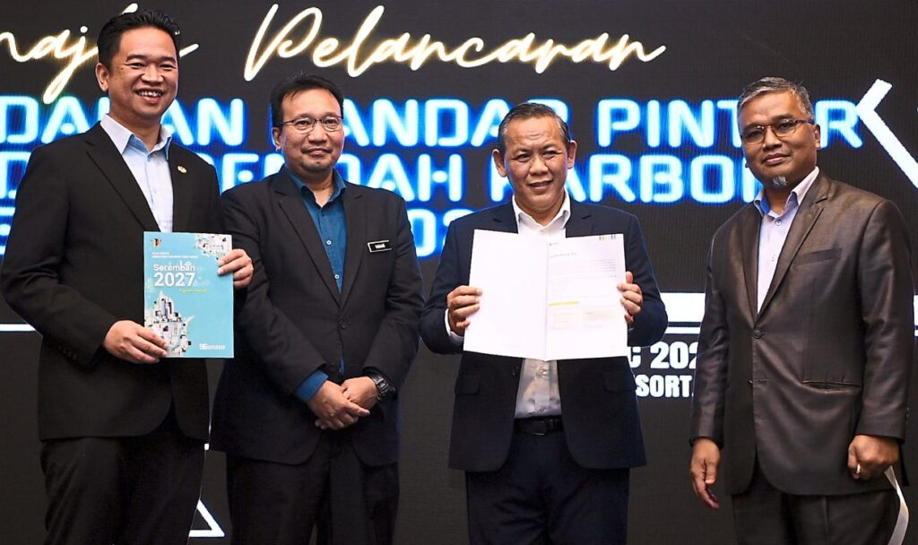 Ambitious goal: Aminuddin (second from right), accompanied by Masri (right) showing the smart city and low carbon emission plan during the launch at Pekan Nilai in Seremban. — Bernama