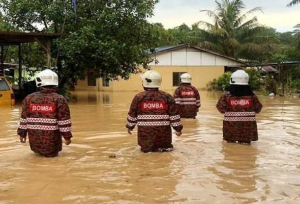 Anggota JBPM membantu membawa keluar mangsa banjir selepas laluan keluar kampung mereka dinaiki air susulan hujan lebat berterusan. - Foto fail/BERNAMA